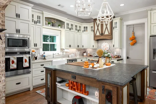 a kitchen with stainless steel appliances granite countertop a stove and white cabinets