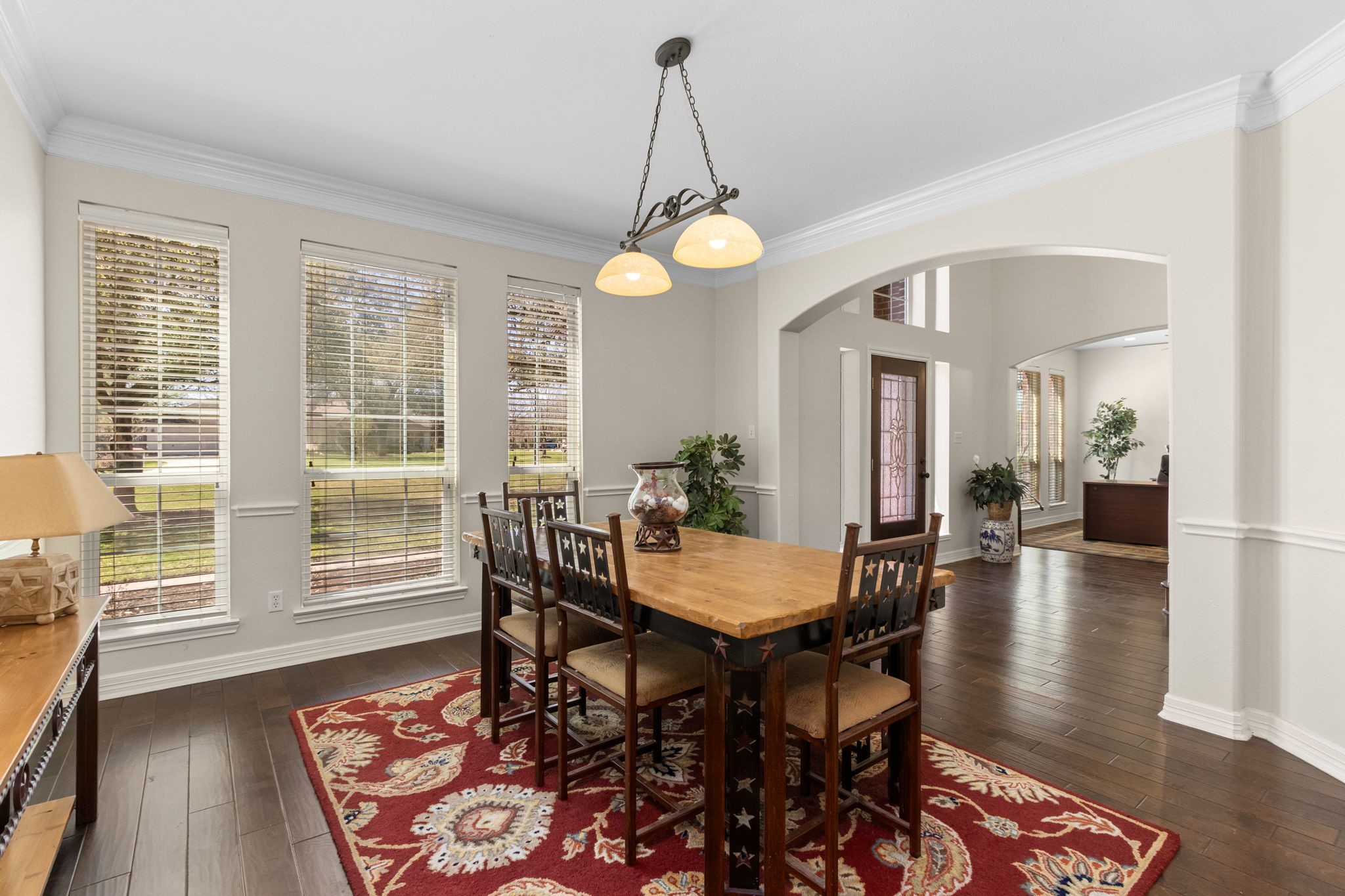 3610 Wellspring Lake Drive Fulshear, TX 77441 - Photo 10 of 45 a dining room with wooden floor a chandelier a wooden table and chairs