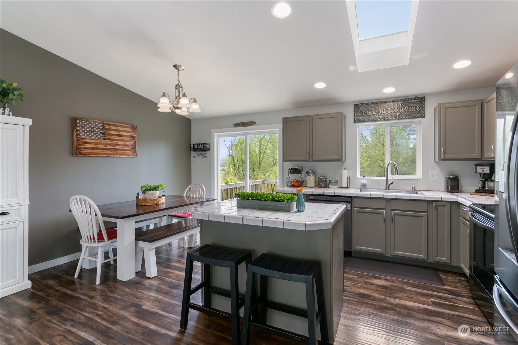 310 Allison Way Nooksack, WA 98276 - Photo 7 of 35 a kitchen with kitchen island granite countertop a dining table chairs and white cabinets