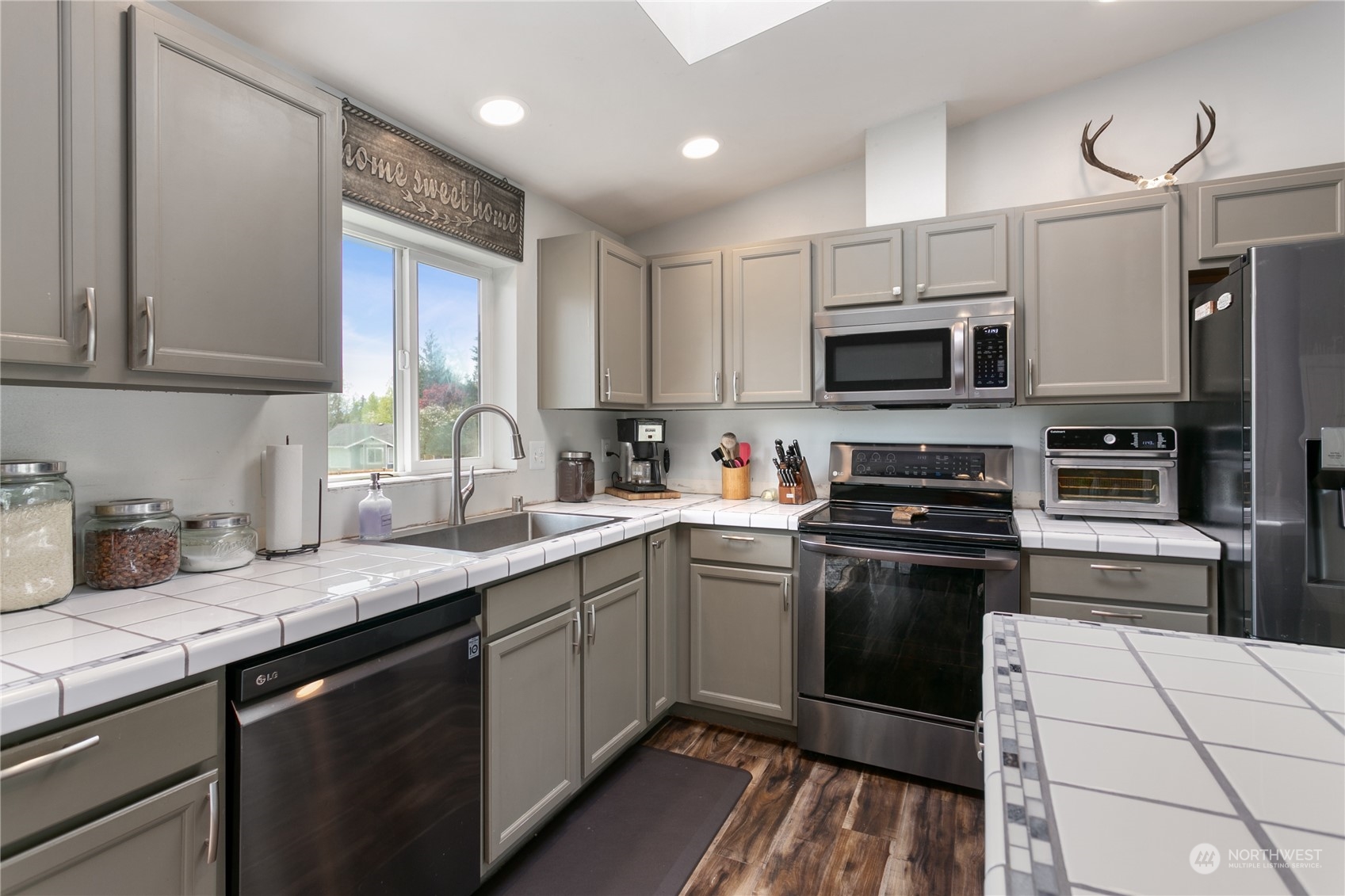 310 Allison Way Nooksack, WA 98276 - Photo 8 of 35 a kitchen with stainless steel appliances a sink dishwasher a stove top oven a refrigerator with island and chairs