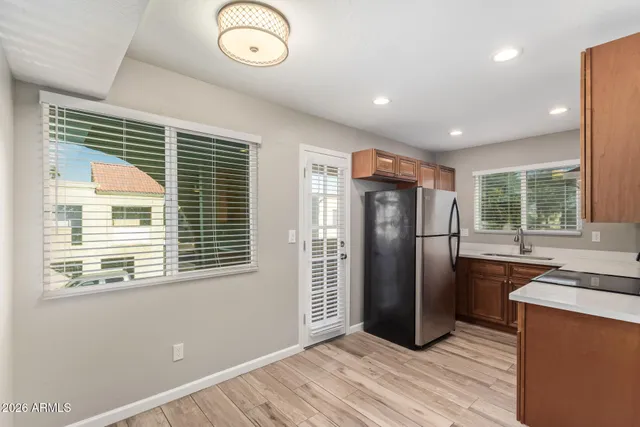 a view of a kitchen with a sink wooden cabinets and stainless steel appliances