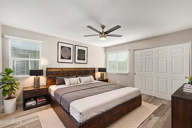 a bedroom with a large bed a potted plant and a window
