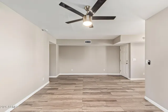 a view of an empty room with wooden floor
