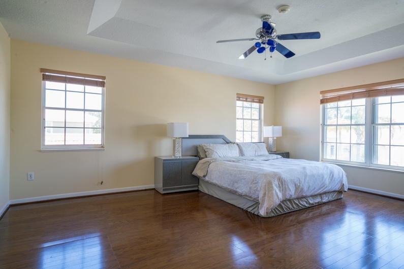 9721 Enchanted Pointe Lane Boca Raton, FL 33496 - Photo 9 of 25 a spacious bedroom with a bed and a chandelier