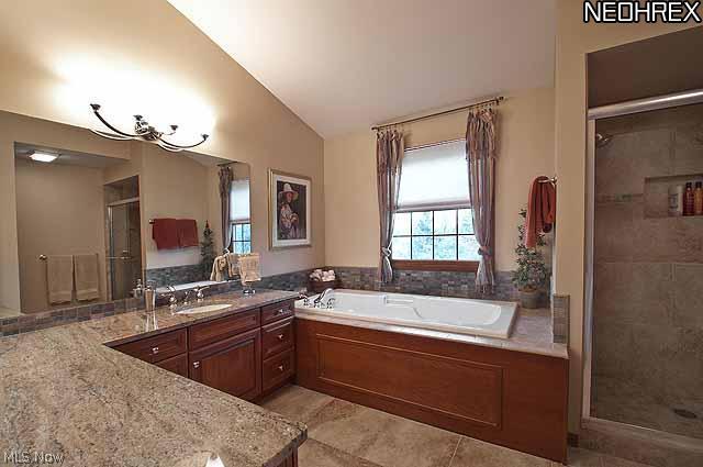 357 Longspur Road Highland Heights, OH 44143 - Photo 12 of 22 Gorgeous master glamour bath features 12 ft. high cathedral ceiling, granite countertop, cherry cabinets with tons of drawers, under-mount Kohler porcelain sink, built in sit-down make-up area, large jetted tub, mosaic tile backsplash and trim, and 18â?� porcelain tile on floors and to ceiling in fabulous large shower with oversized rain-style shower head