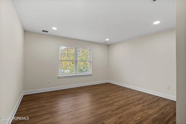 an empty room with wooden floor and window