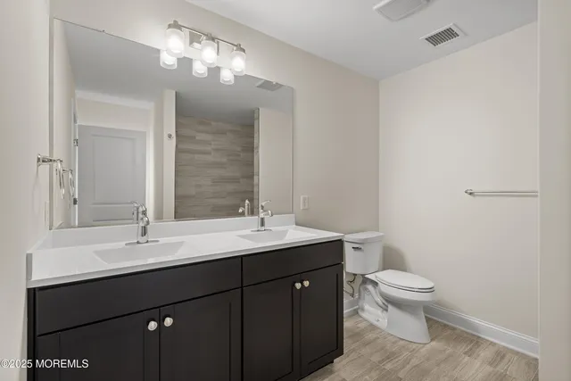 a bathroom with a toilet a sink and mirror