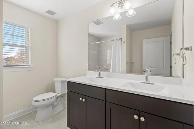 a bathroom with a sink a toilet and a mirror