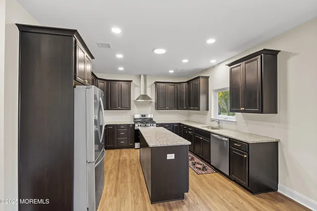 a kitchen with stainless steel appliances granite countertop a sink a stove and a refrigerator