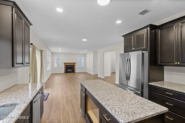 a kitchen with granite countertop a refrigerator and wooden cabinets