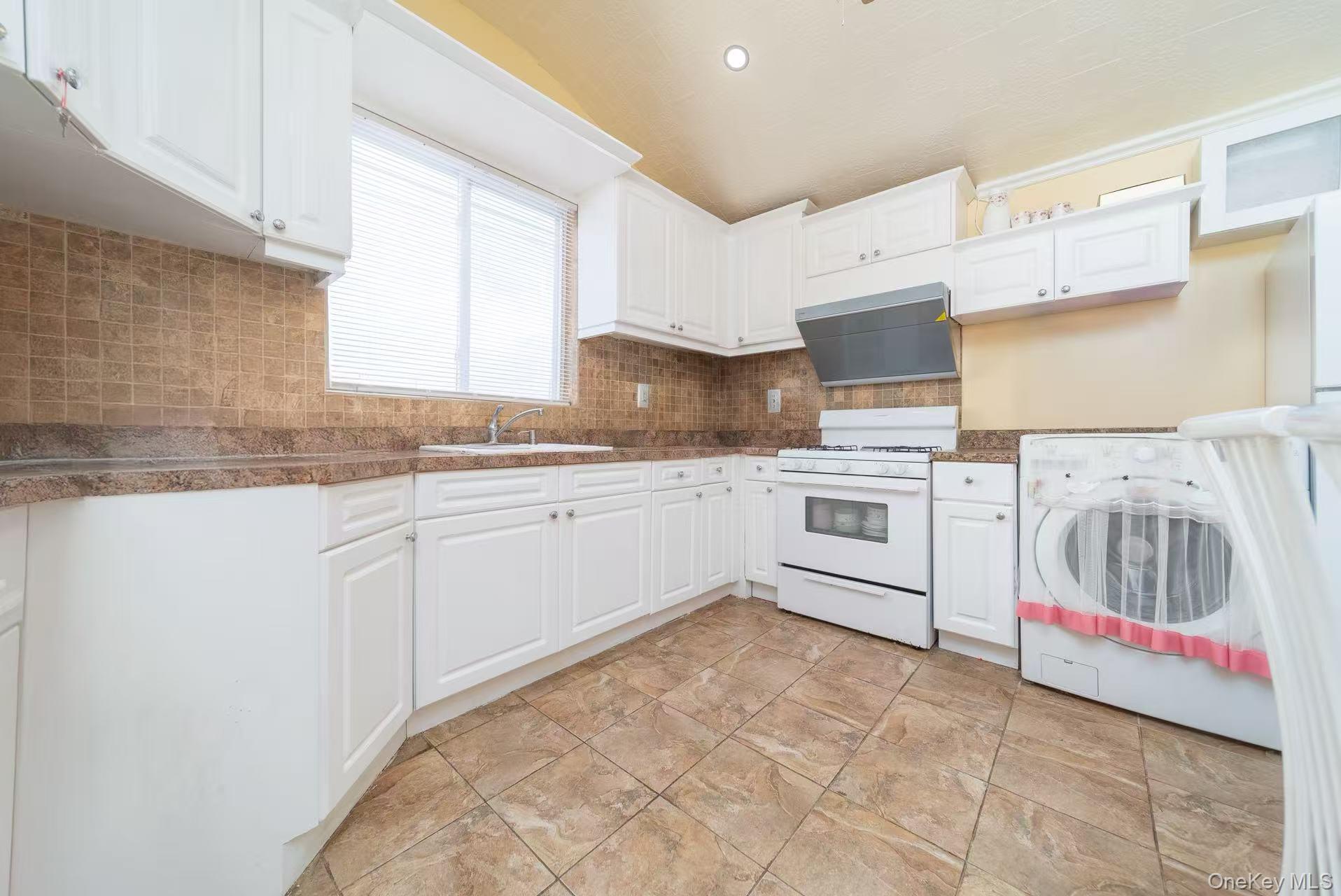 10 Church Street Queens, NY 11414 - Photo 6 of 19 Kitchen with washer / clothes dryer, white gas stove, dark countertops, white cabinets, and recessed lighting