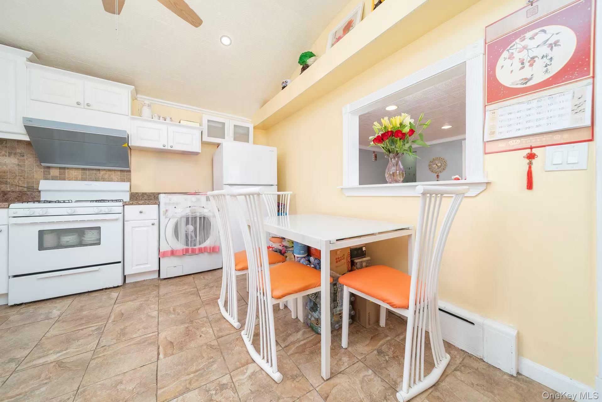 10 Church Street Queens, NY 11414 - Photo 7 of 19 Kitchen featuring white cabinets, white appliances, washer / dryer, range hood, and recessed lighting
