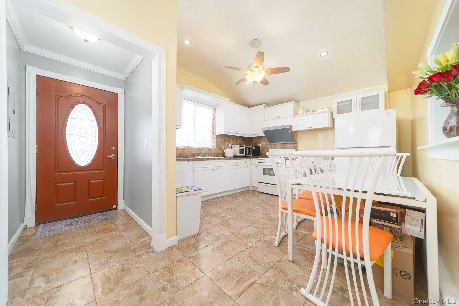 10 Church Street Queens, NY 11414 - Photo 8 of 19 Kitchen with white cabinetry, white appliances, lofted ceiling, glass insert cabinets, and tasteful backsplash