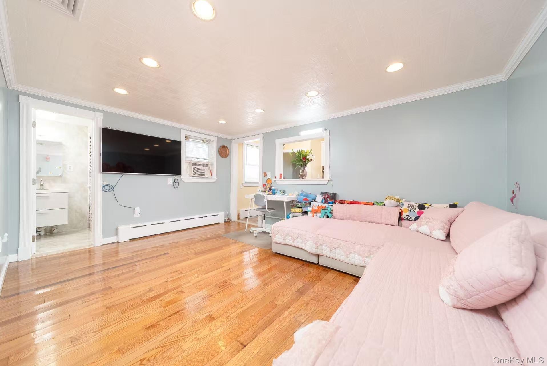 10 Church Street Queens, NY 11414 - Photo 9 of 19 Bedroom with ornamental molding, light wood-style floors, baseboard heating, recessed lighting, and cooling unit