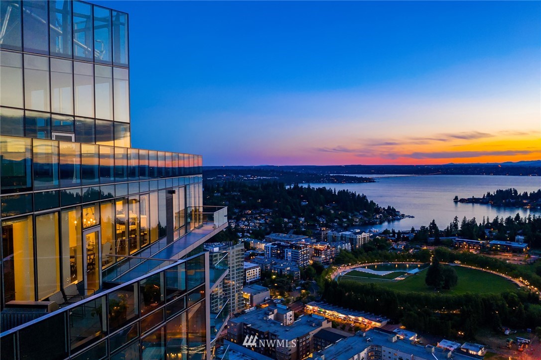 a city view with tall buildings and cars parked on road