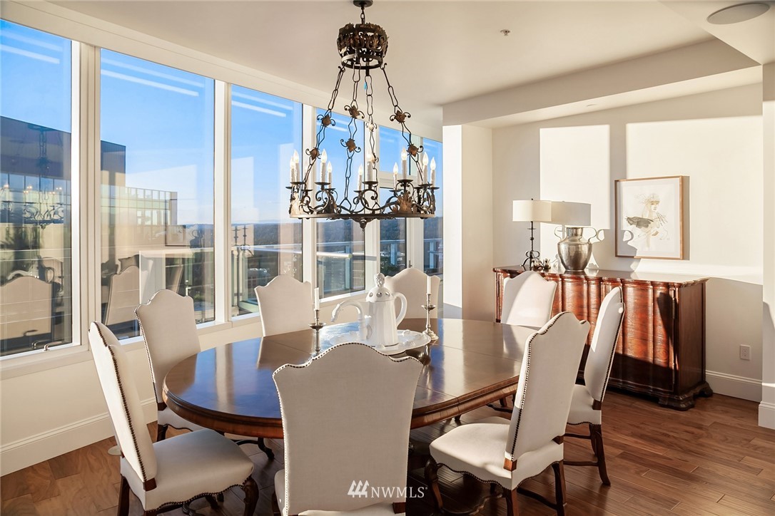10700 Northeast 4th Street, Unit 4202 Bellevue, WA 98004 - Photo 18 of 40 a dining room with wooden floor a chandelier a glass table and chairs