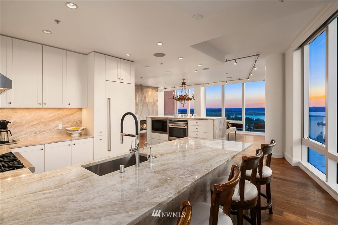 10700 Northeast 4th Street, Unit 4202 Bellevue, WA 98004 - Photo 10 of 40 a kitchen with stainless steel appliances granite countertop a table chairs in it and wooden floors