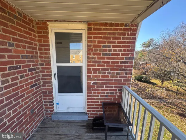 a view of a balcony with wooden floor and fence and trees