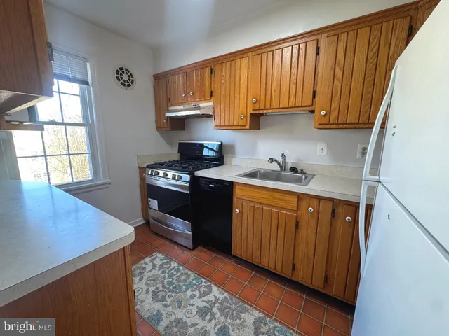 a kitchen with stainless steel appliances granite countertop wooden cabinets a sink and a stove