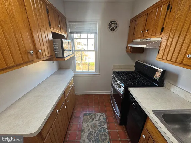 a kitchen with granite countertop a sink stove and cabinets