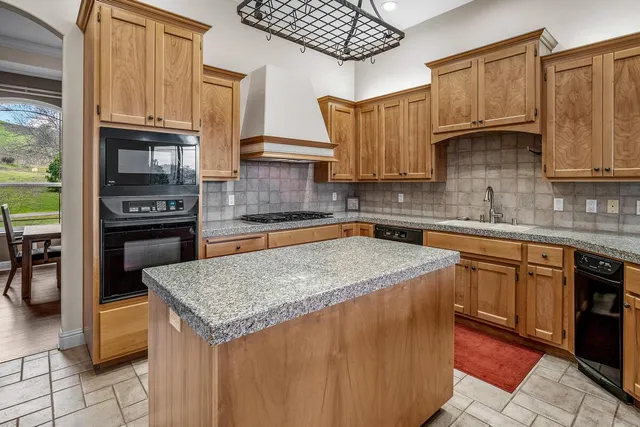 a kitchen with stainless steel appliances granite countertop a sink stove and cabinets