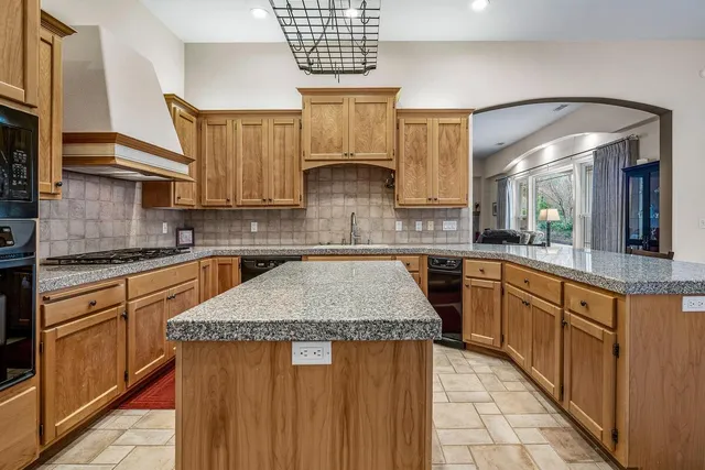 a kitchen with stainless steel appliances granite countertop a stove a sink and a microwave