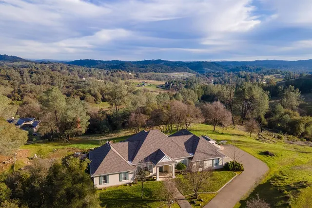 an aerial view of residential houses with outdoor space and lake view