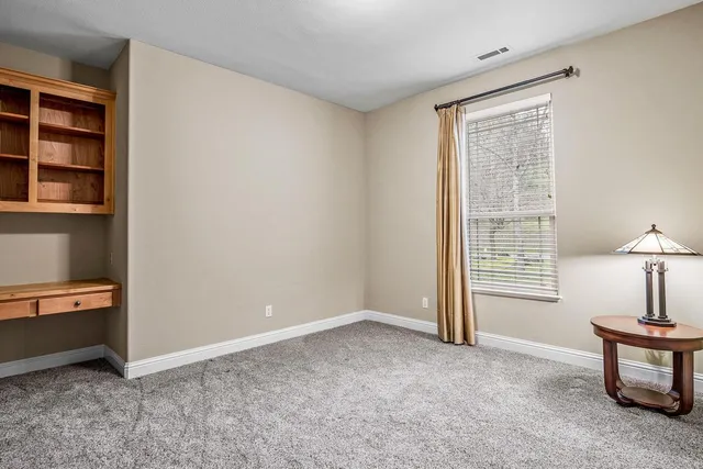 a view of a workspace with furniture and a window