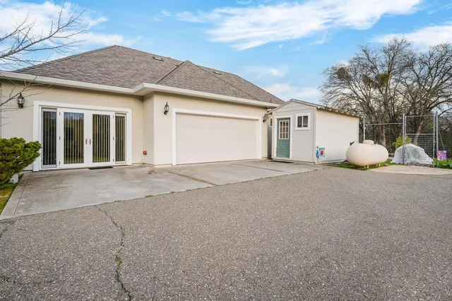 a view of a house with backyard and a tree