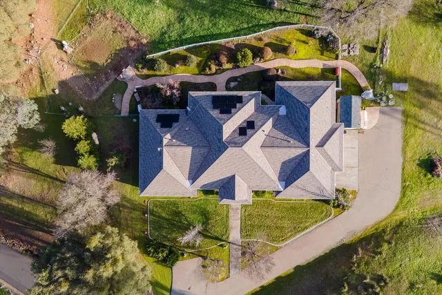an aerial view of a house with a garden and lake view
