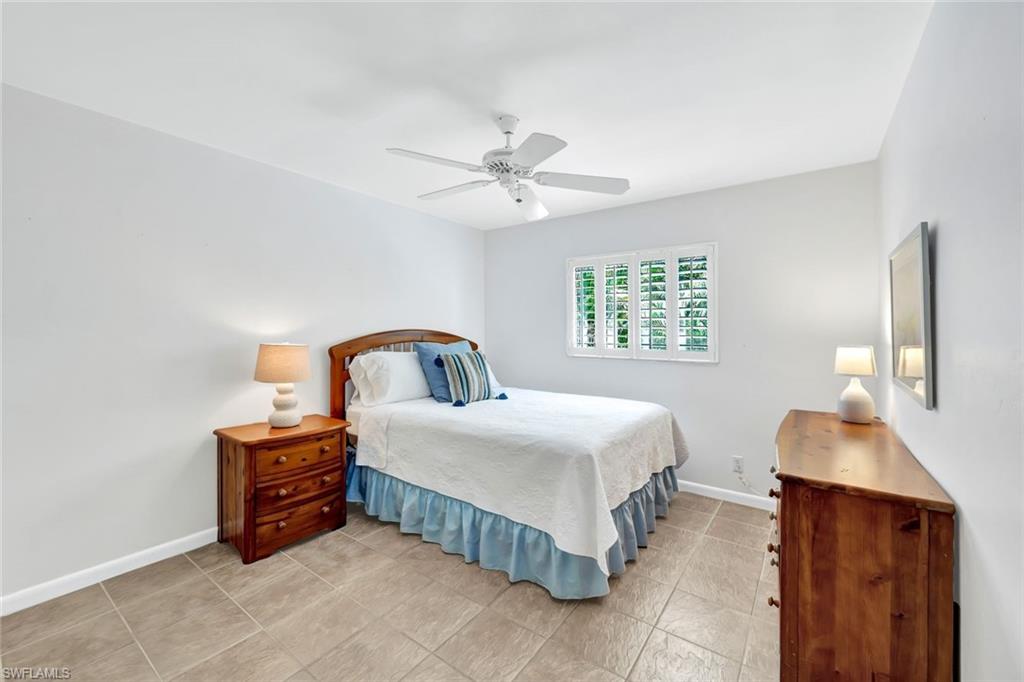 4530 13th Avenue Southwest Naples, FL 34116 - Photo 19 of 30 a spacious bedroom with a bed and a table