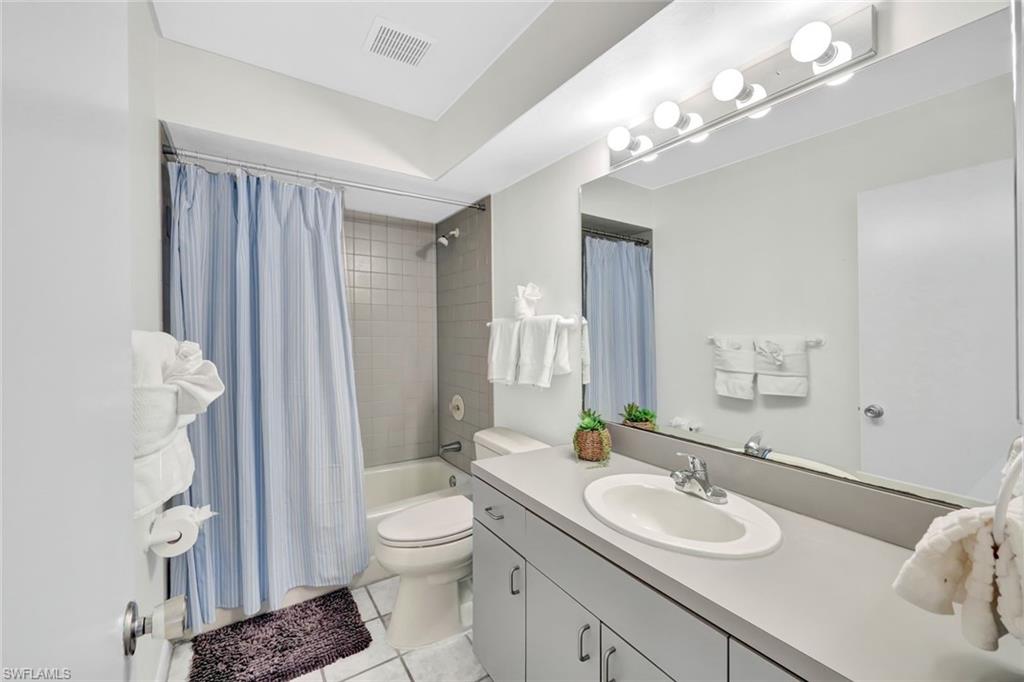 4530 13th Avenue Southwest Naples, FL 34116 - Photo 20 of 30 a bathroom with a granite countertop sink toilet a mirror a vanity and shower