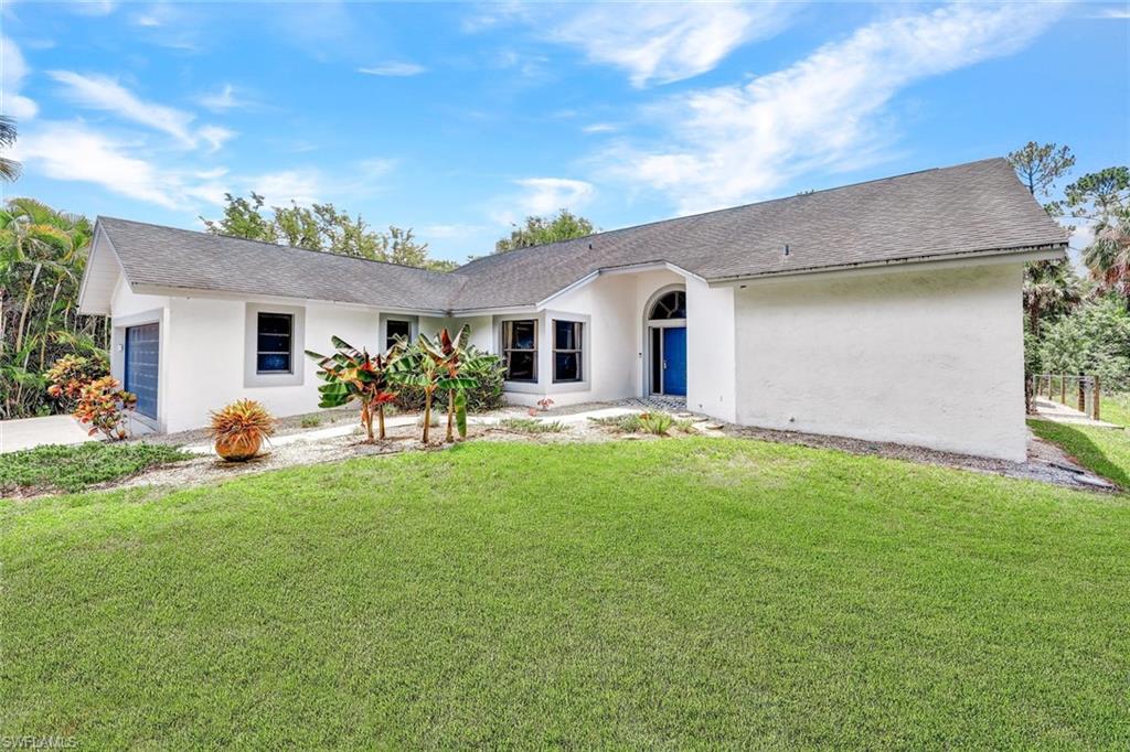 4530 13th Avenue Southwest Naples, FL 34116 - Photo 2 of 30 a front view of house with yard and outdoor seating