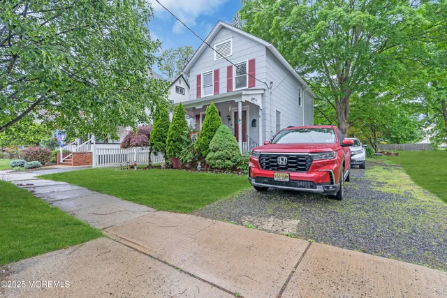 a front view of a house with a garden and parking