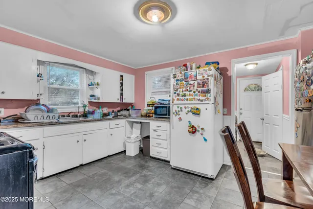 a white kitchen with cabinets and white appliances