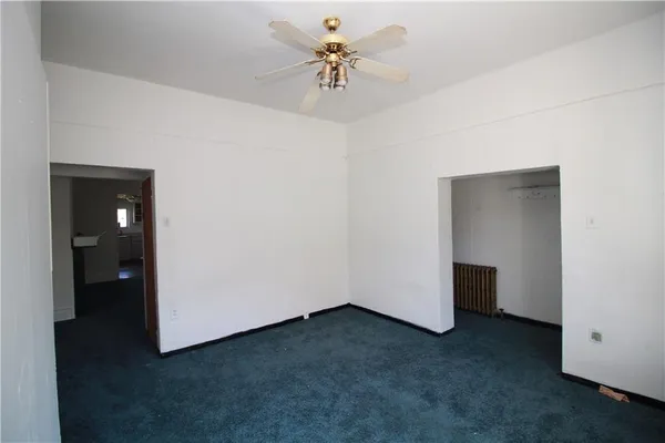 an empty room with closet and a chandelier fan