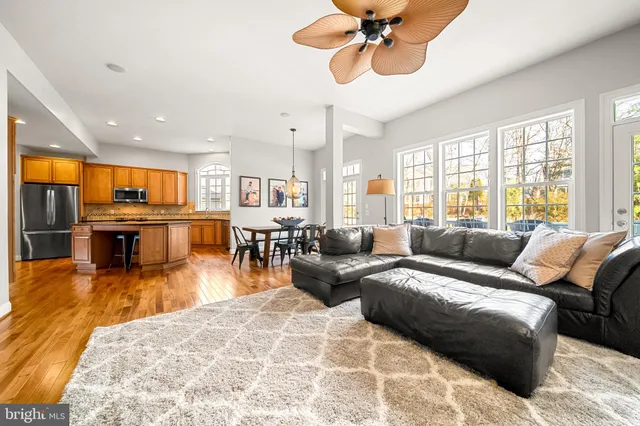 a living room with furniture kitchen view and a large window