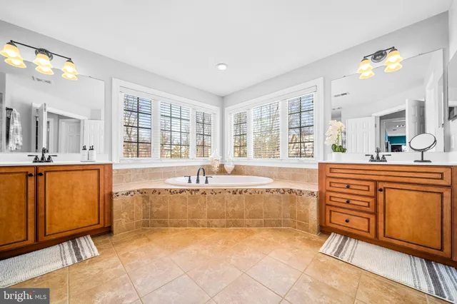a spacious bathroom with a granite countertop tub sink and mirror
