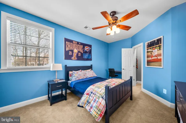 a bedroom with two beds and ceiling fan