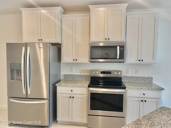 a kitchen with cabinets stainless steel appliances and a counter space