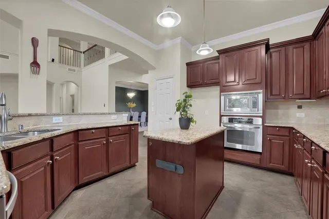 a kitchen with kitchen island granite countertop wooden cabinets and white appliances
