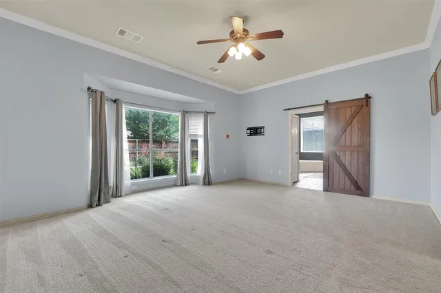 a view of a big room with windows and chandelier fan