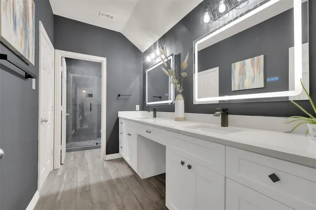 a en suite bathroom with a granite countertop sink and a mirror