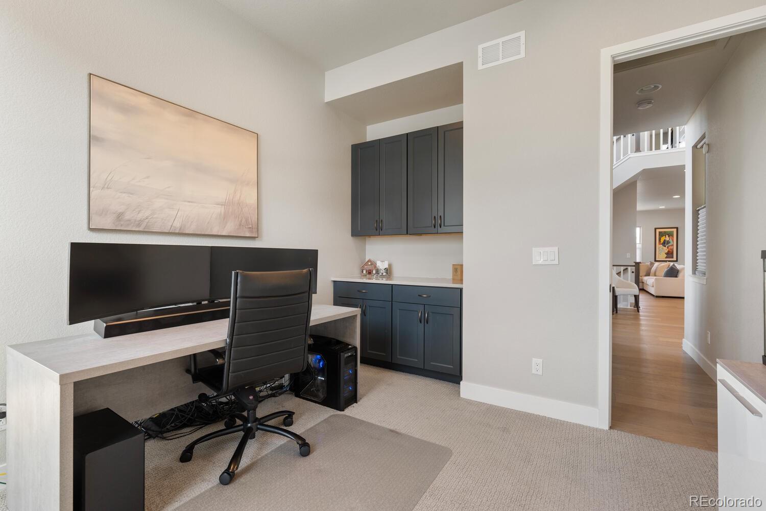 507 Red Thistle Drive Highlands Ranch, CO 80126 - Photo 13 of 42 a view of a workspace with furniture and a flat screen tv