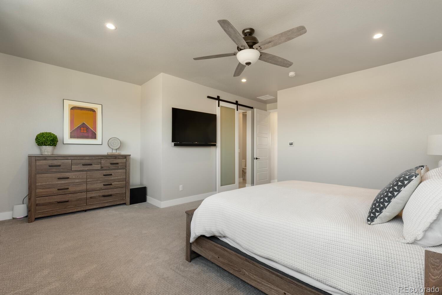 507 Red Thistle Drive Highlands Ranch, CO 80126 - Photo 15 of 42 a spacious bedroom with a bed and a flat screen tv