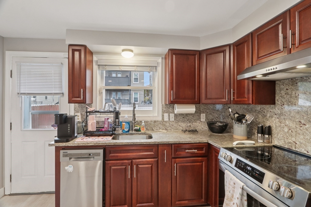 19 Delford Street, Unit 1 Boston, MA 02131 - Photo 5 of 25 a kitchen with stainless steel appliances granite countertop a sink stove and cabinets