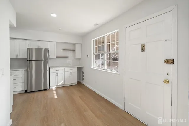 a view of kitchen with a refrigerator cabinets and wooden floor