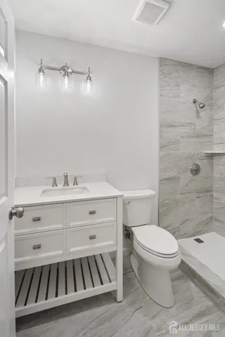 a bathroom with a sink a toilet and shower
