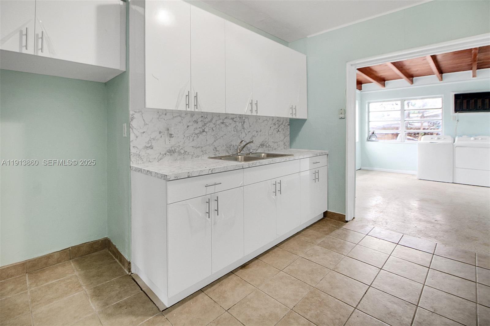 3462 Southwest 27th Street Miami, FL 33133 - Photo 3 of 17 a utility room with granite countertop cabinets and washer