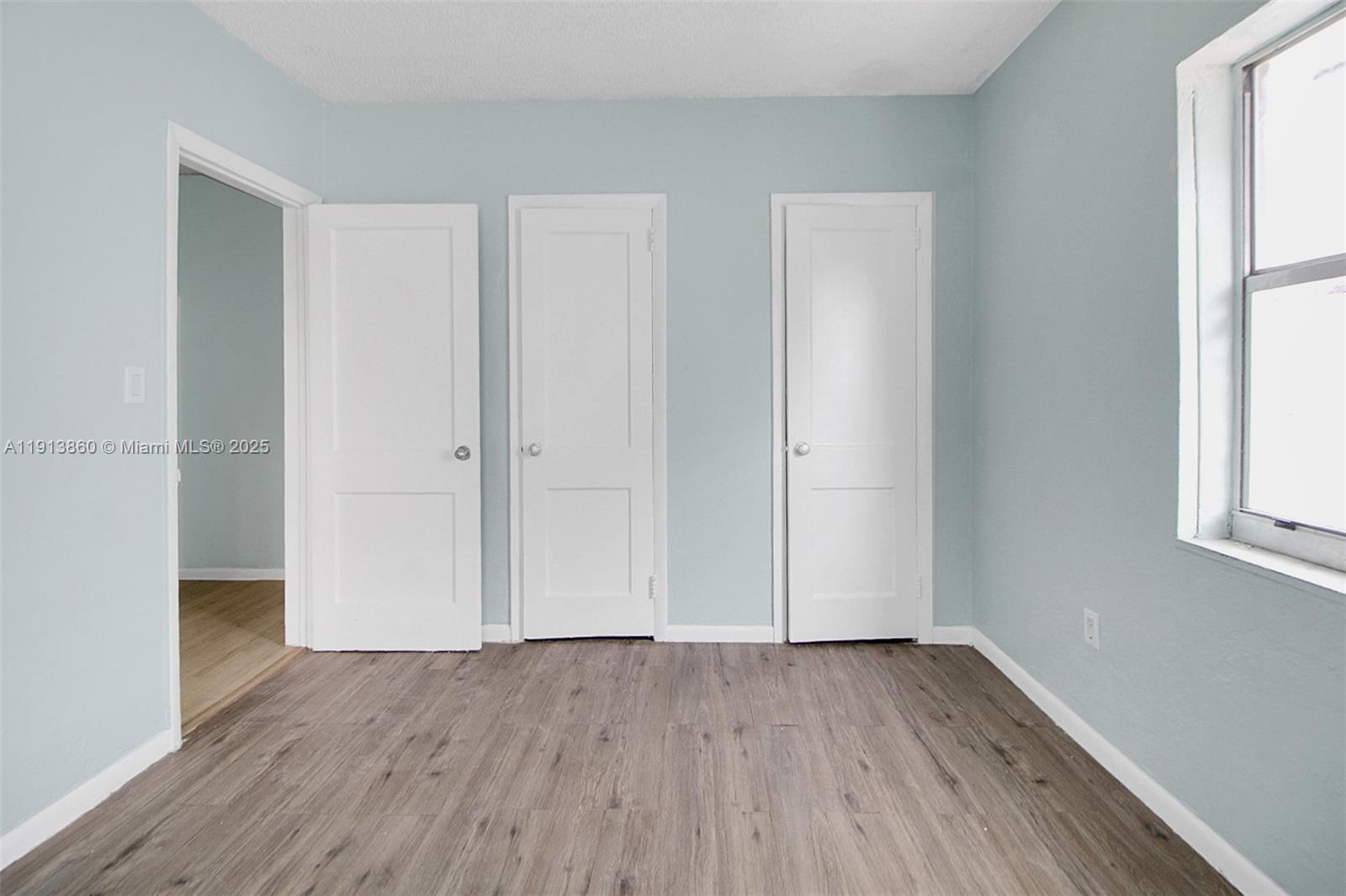 3462 Southwest 27th Street Miami, FL 33133 - Photo 8 of 17 an empty room with wooden floor and windows